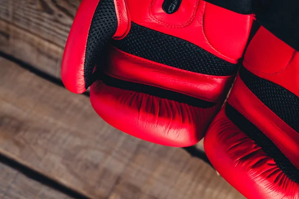 Makrodetail roter Boxhandschuhe. hölzerner Hintergrund. — Stockfoto