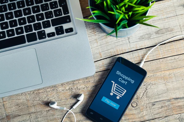 Carrito de compras en la pantalla del teléfono inteligente. Detalle del lugar de trabajo . — Foto de Stock