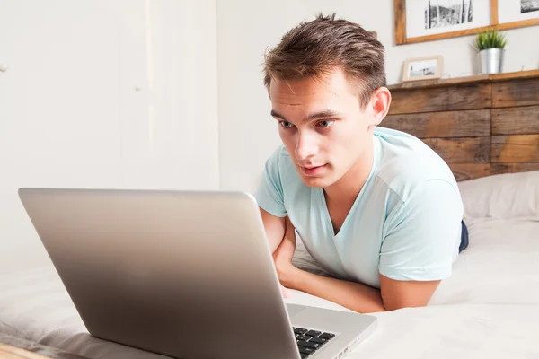 Jeune étudiant utilisant un ordinateur portable à la maison . — Photo