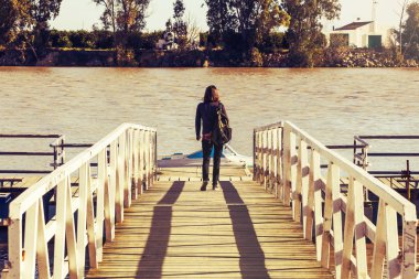 Nehir iskelede yürüyen kadın.