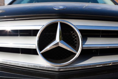 Malaga, İspanya - 2 Aralık 2015: Mercedes Benz araba logosu önünde araba kılavuz.