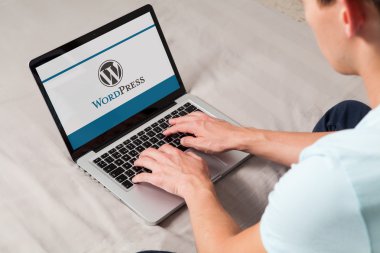 Malaga, İspanya - 10 Kasım 2015: Wordpress marka logosu bilgisayar ekranında. Klavyede yazarak adam. Bir ücretsiz ve açık kaynak bloglama aracı ve bir içerik yönetim sistemi (Cms WordPress olduğunu).