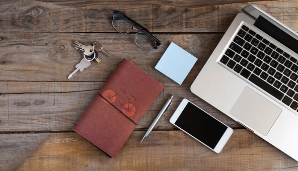 Portátil abierto, teléfono inteligente, gafas, notebook y llaves. Concepto de espacio de trabajo . — Foto de Stock