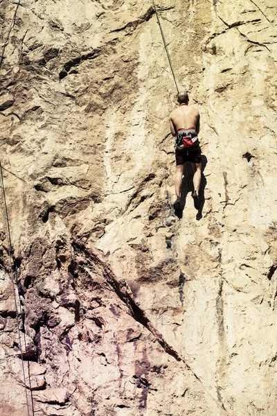 Man klimmen een berg muur. Vintage filter. — Stockfoto