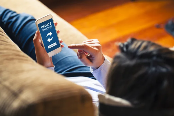 Mujer tocando un teléfono móvil con el aviso de actualización . — Foto de Stock