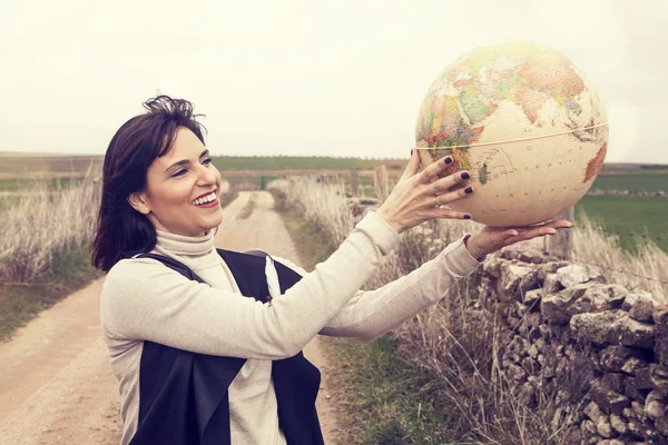 Lachende vrouw met een globe. — Stockfoto