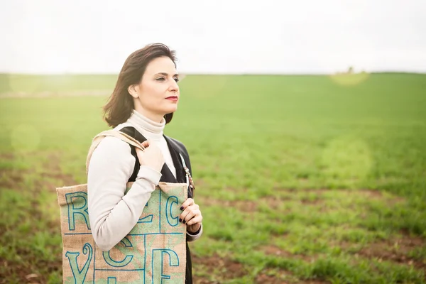 Brünette Frau trägt eine umweltfreundliche Tasche auf der Schulter. — Stockfoto