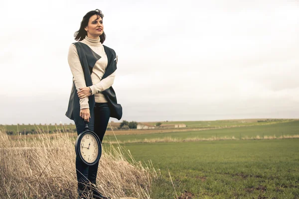 Vrouw met een vintage klok met een hand. Tijd concept. — Stockfoto