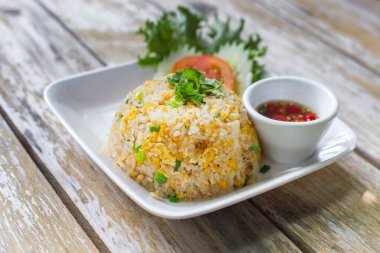 Fried Rice with egg in the white dish on wooden table