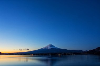 the mountain Fuji at dawn with peaceful lake reflection on the lake kawaguchiko , Japan.