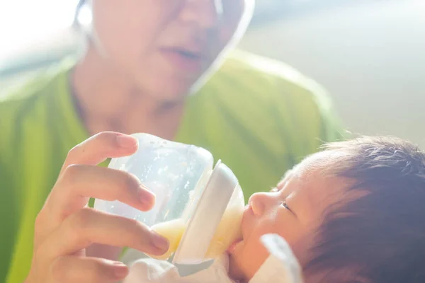 Anne sütü yiyen bebeği besler.