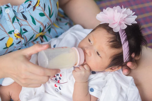 Anne, biberondan süt yiyen bebeği besler.