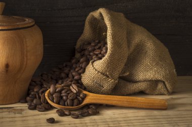 Kahve fincanı ve çay tabağı ahşap bir masada. Koyu arkaplan.