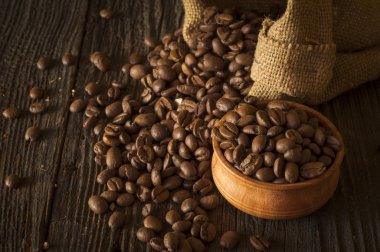 Kahve fincanı ve çay tabağı ahşap bir masada. Koyu arkaplan.