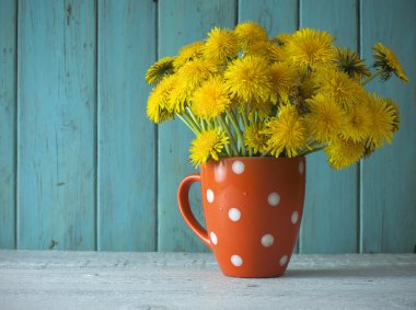 Antika ahşap masa üzerinde vazoda sarı dandelions demet
