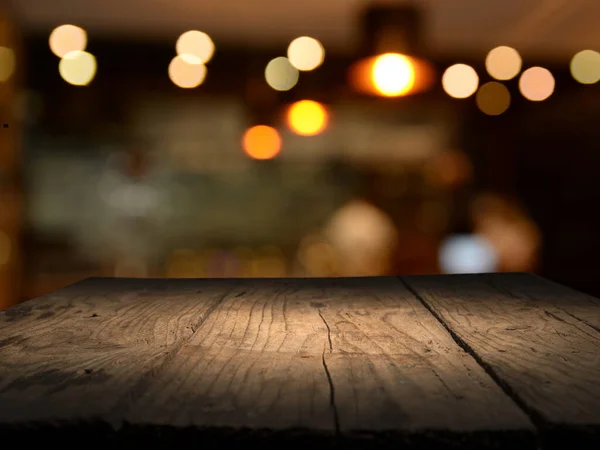 Obraz dřevěného stolu před abstraktním rozmazaným pozadím obnovujících světel — Stock fotografie