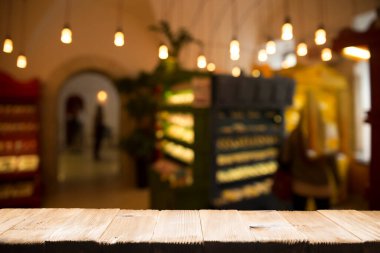 Restoranın soyut bulanık arka planının önündeki boş, siyah ahşap masa. Ürünlerinizi görüntülemek ya da montajlamak için kullanılabilir.