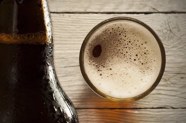 Copo de cerveja leve em um pub escuro. — Fotografia de Stock