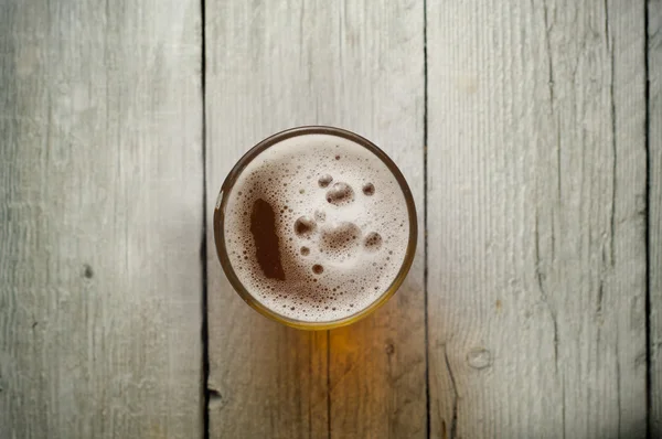Kühles, erfrischendes dunkelbernsteinfarbenes Bier vor Hintergrund — Stockfoto