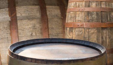 Köy mahzenindeki ahşap fıçılar, sıcak kehribar ışığı meşe kütükleri ve gübre rengi, şarap ve viski için hazırlanmış fıçılar, ince ince farklar.