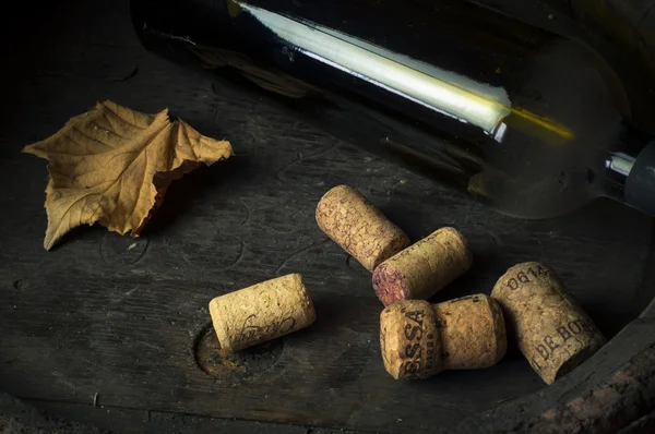 şişe beyaz şarap, üzüm ve mantarlar ahşap tablo