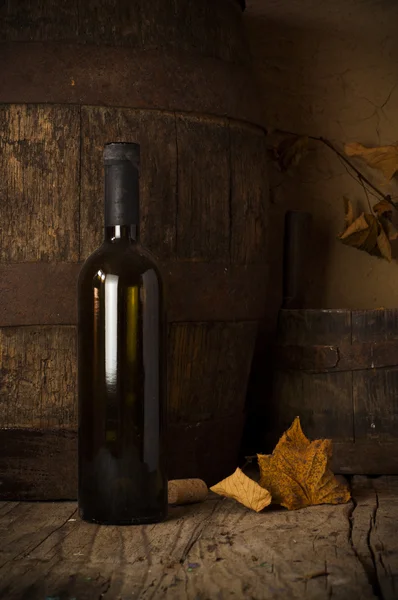 Still life with wine bottles, glasses and oak barrels. — Stock Photo, Image