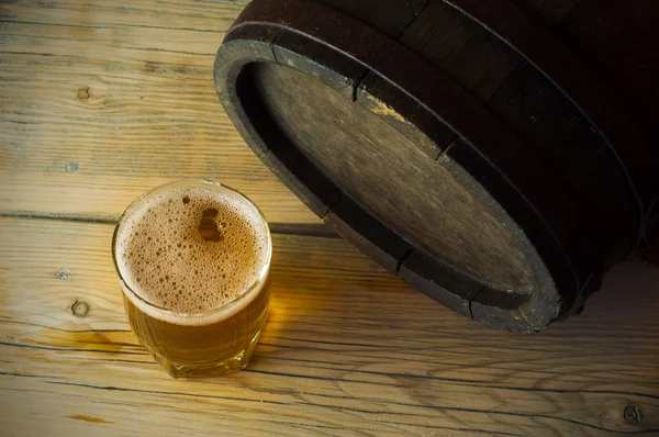 Biervat met glas op houten tabelachtergrond — Stockfoto