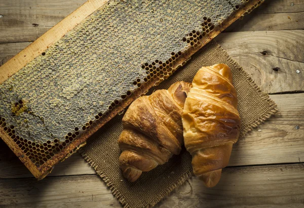 Croissants con miel en un estilo rústico — Foto de Stock