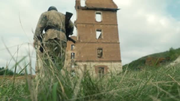 Odbudowa historyczna, bitwa o II wojnę światową. Niemieccy żołnierze Wehrmachtu maszerują po polu w pełnym mundurze z bronią. — Wideo stockowe
