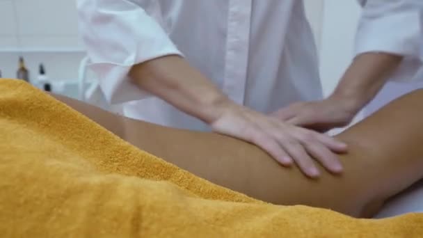 As mãos femininas massageiam a perna de uma jovem. Conceito de cuidado corporal. — Vídeo de Stock