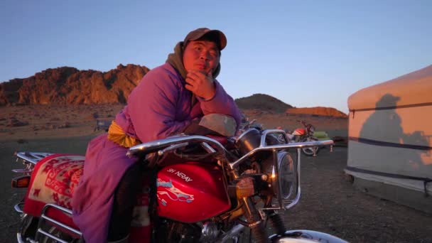 Ulan Bator Mongolia, 29 de junio de 2019: un mongol con ropa nacional en una motocicleta cerca de una yurta — Vídeo de stock