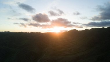 Moğol Çölü 'ndeki dağ manzarası. Dağların arkasında gün batımı.