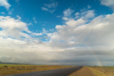 Güneşli ve güzel bir dağda gökkuşağının başlangıcı.