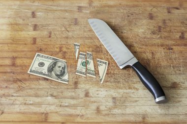 Kesme tahtası bıçak ve bir yüz dolarlık banknot kesmek