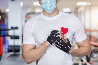 Spor salonunun arka planında sevgililer günü kartı olan bir erkek sporcu..