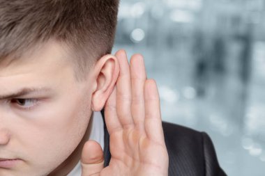 Genç iş adamı bulanık arka planda dinliyor.