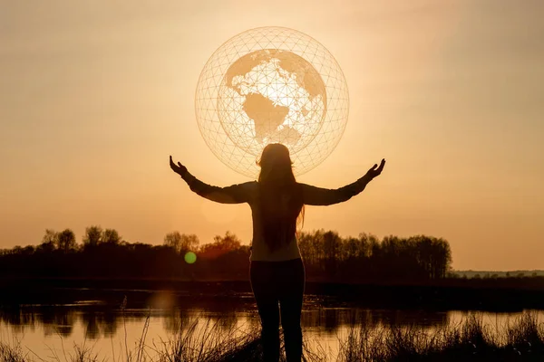 Global network support concept. Woman stands in front of the global network on the background of a sunny sunset.