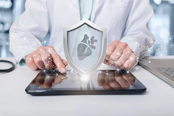 Patient heart insurance and protection concept. Doctor shows on the computer shield with heart.