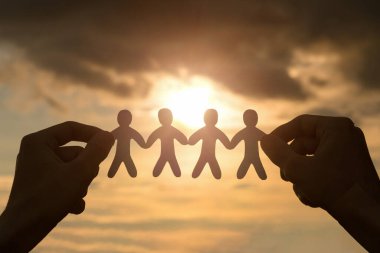 El ele tutuşan bir grup kağıt, arka plandaki insanları kesiyor..