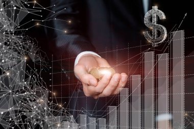 İş adamı, büyüyen finansal büyüme grafiğinin arka planına karşı bir avuç dolusu bozuk para gösteriyor.