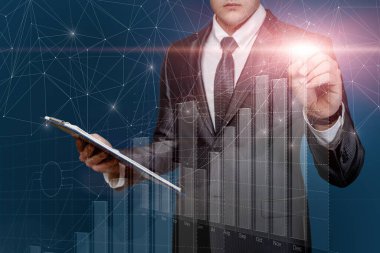 İşadamı mavi arka planda finansal büyüme grafiğiyle çalışıyor.