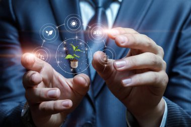 İş adamı elleri bulanık arkaplanda alternatif enerji kaynaklarıyla etkileşim halindedir.