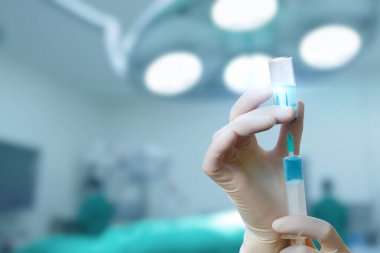 Prosedüre hazırlanıyorum. Bir tıp uzmanı, parlak bir ameliyathanede şırınga hazırlar..