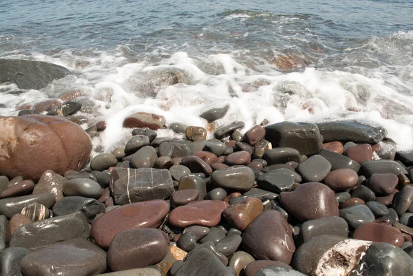 Pebbles on the Beach Being Washed by Wave — Stock Photo, Image