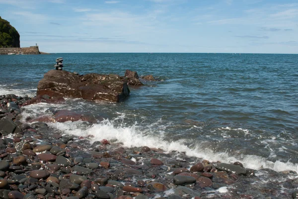 Stacked Pebble Tower being Washed by Wave — Stock Photo, Image