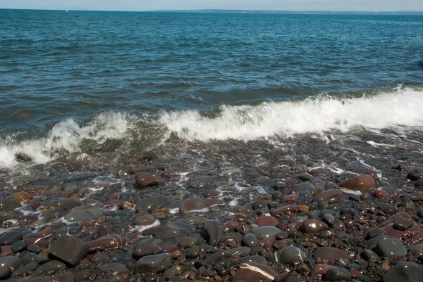 Хвильове миття над гальковим пляжем — стокове фото