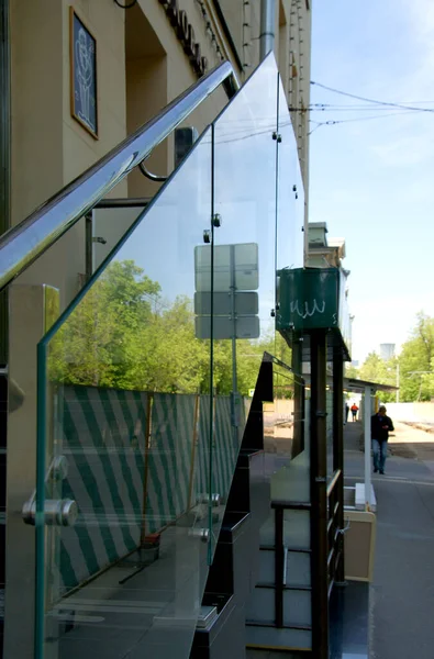Glass railing at the stairs with handrails