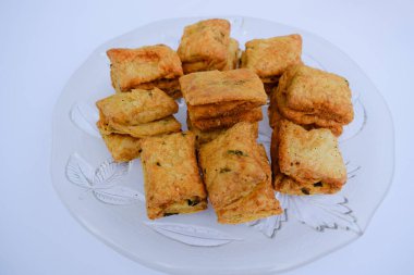 Hint çay saati atıştırmalığı Khaari bisküvisi. Namkeen tuzlu Masala Khari beyaz tabakta servis ediliyor. Beyaz arkaplanı kapat. Hint yemeği..