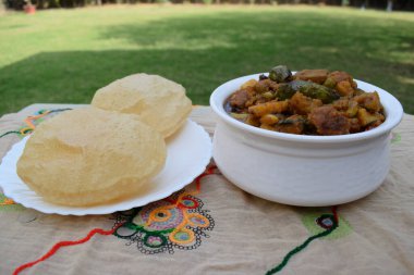 Hint Gujarati Öğle Yemeği ya da Puri ve Undhiyu ya da Undhiya körili akşam yemeği ve makar sankranti festival sezonu için papad sarması. Evin arka planında restoran gibi bir bahçe var.