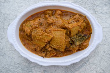 Suran ki Sabji oval bir tabakta servis yaptı. Sarı arka planda Hint egzotik mutfağı. Lezzetli Hint körisi